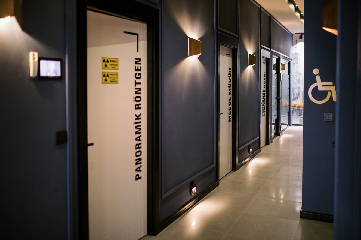 DentAden klinik koridoru — Panoramik Röntgen, Mesul Müdür ve tedavi odalarının kapıları